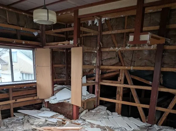 室内の写真。壁のボードが取り除かれ、お家を支えていた木の柱が見える状態。