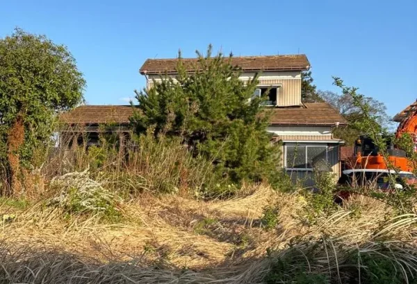 今回解体する住宅の全景。お庭の草木や手前に雑草が生い茂っている。
