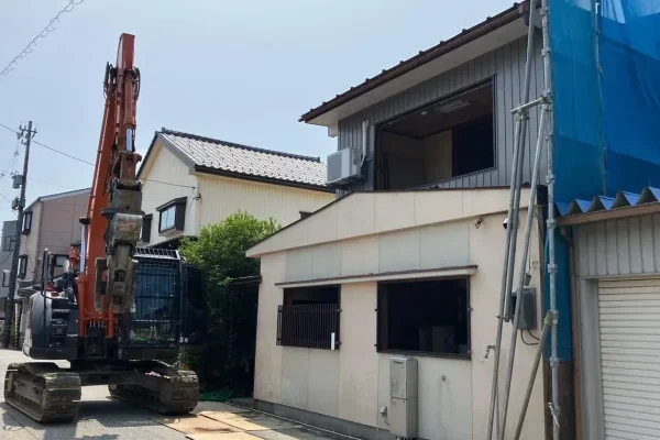 家の前にオレンジ色の重機が停まっている