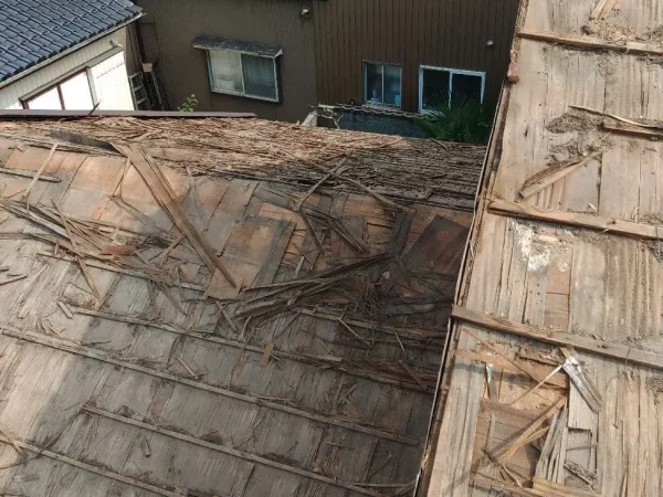 瓦の降ろされた屋根から下を見下ろす