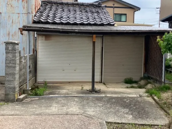 近隣に近く建てられている車庫。屋根部分が少し凹んでおり、老朽化が目立っている。