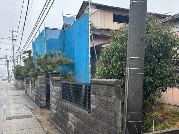 家の道路側には足場が組まれ青い養生がされている