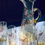 光を浴びて輝く、鳥と花が描かれたグラス