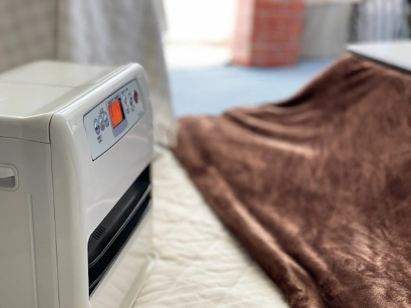 部屋に置かれた石油ファンヒーターとこたつ