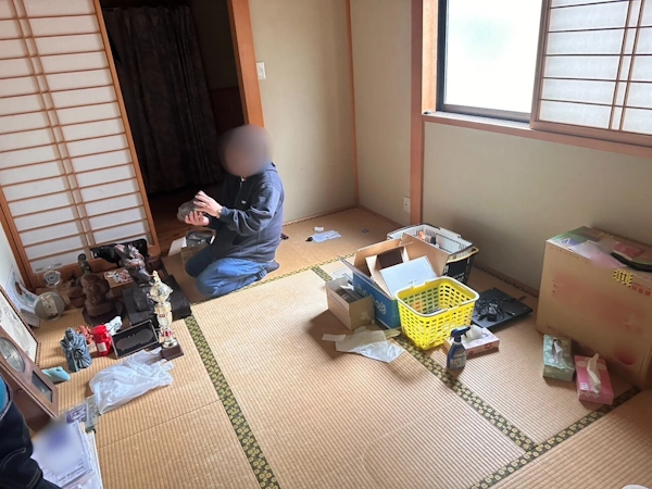 不用品回収の現場で、お客様の品物を一つずつ確認する、エイキの買取専門スタッフ