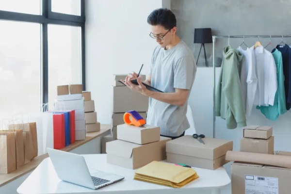 査定のイメージ写真。Tシャツを着たメガネの男性が品々を査定中