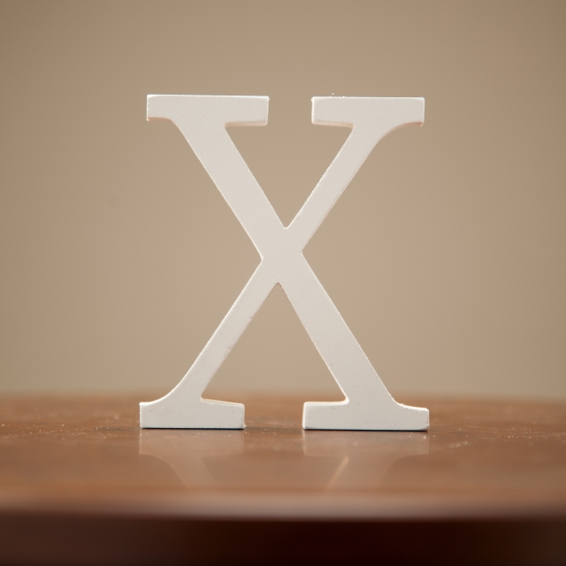 机に、白色のXのロゴが置かれている様子